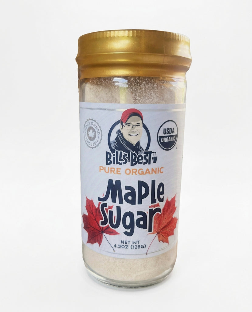 A glass jar of Bill's Best Pure Organic Maple Sugar with a gold metal lid and a white label featuring red maple leaves and a USDA Organic seal, set against a plain white background.