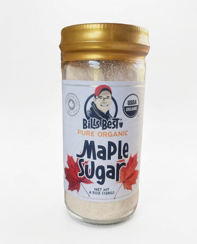 A glass jar of Bill's Best Pure Organic Maple Sugar with a gold metal lid and a white label featuring red maple leaves and a USDA Organic seal, set against a plain white background.